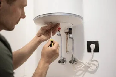 Licensed plumber repairing a residential hot water system in Emerald, Queensland.