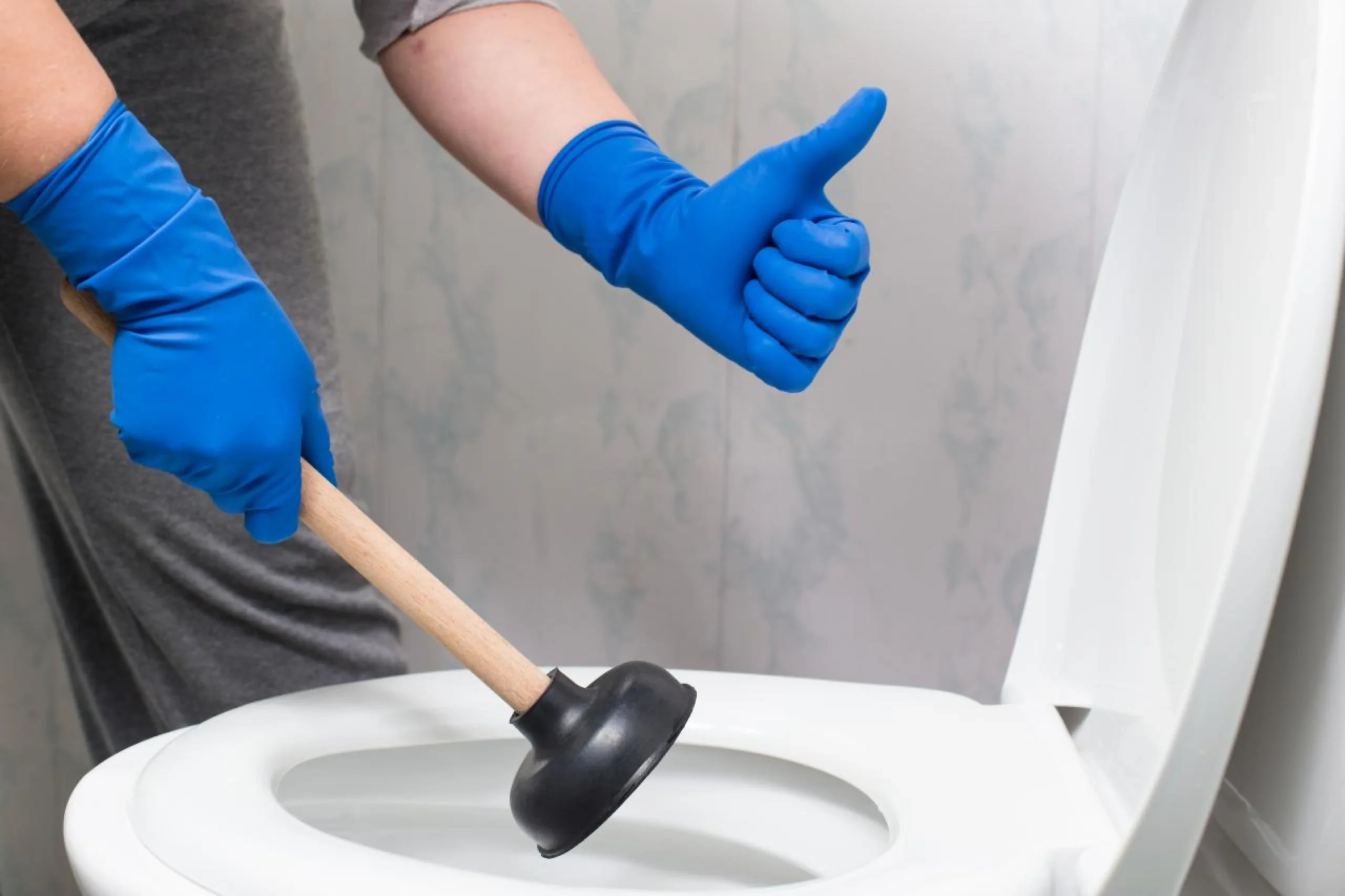 Plumber clearing a blocked toilet drain in Emerald, Queensland.