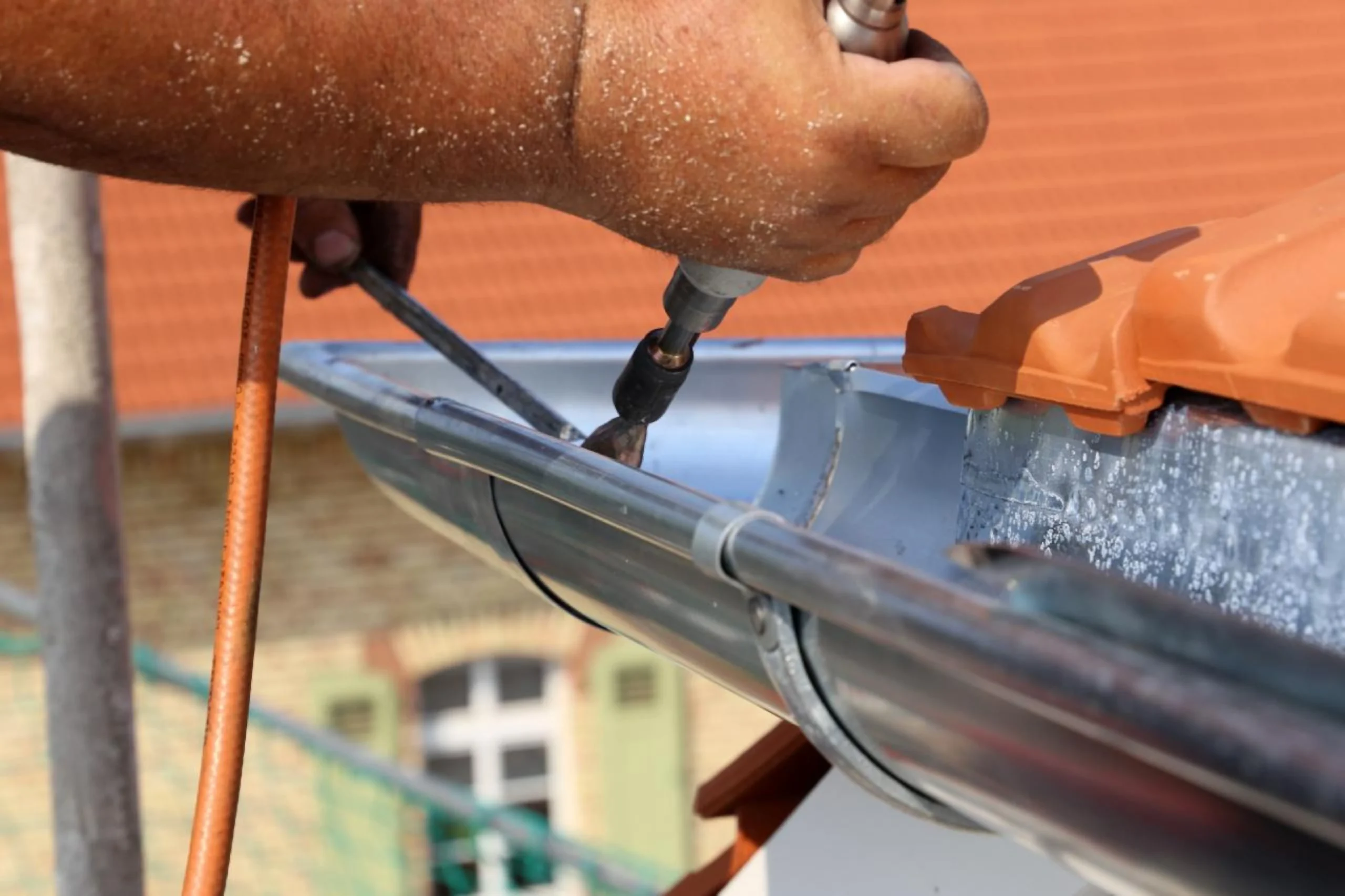 Roof plumber carrying out roof plumbing work on guttering in Emerald, Queensland.